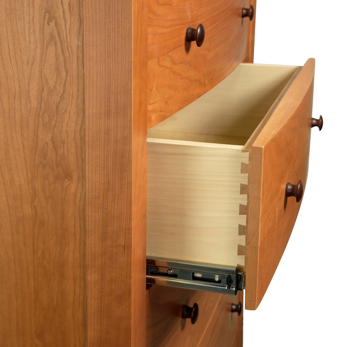 A drawer is open in a wooden chest of drawers.