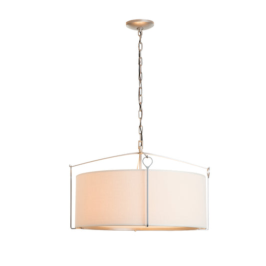A modern Bow Pendant light with a beige shade and brushed metal top, handcrafted by Hubbardton Forge, suspended from a chain attached to a matching ceiling fixture.