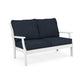 A modern two-seater POLYWOOD Braxton Deep Seating Settee with a white frame and deep blue cushions, isolated on a white background. Made from recycled plastic lumber, the design is simple and sleek, suitable for contemporary interior decor.