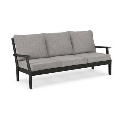 A modern three-seater outdoor sofa with a black metal frame and light gray cushions, isolated on a white background. The  POLYWOOD Braxton Deep Seating Sofa from POLYWOOD.