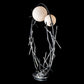 The Brindille Ring Lamp by Hubbardton Forge showcases handcrafted American artistry with two white globes and a sculptural, branch-inspired silver base.