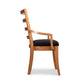 Bromley Ladder-Back Chair by Vermont Woods Studios, crafted from natural wood with a black seat and curved arms, shown in profile.