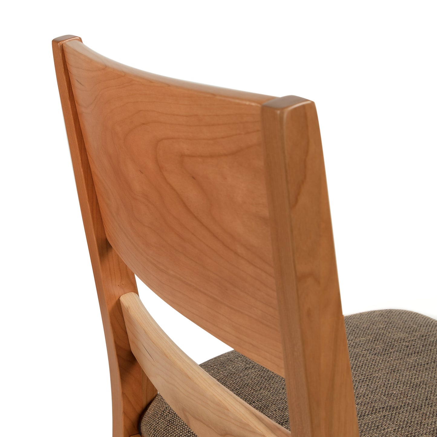 The back of a wooden chair with a tan seat.