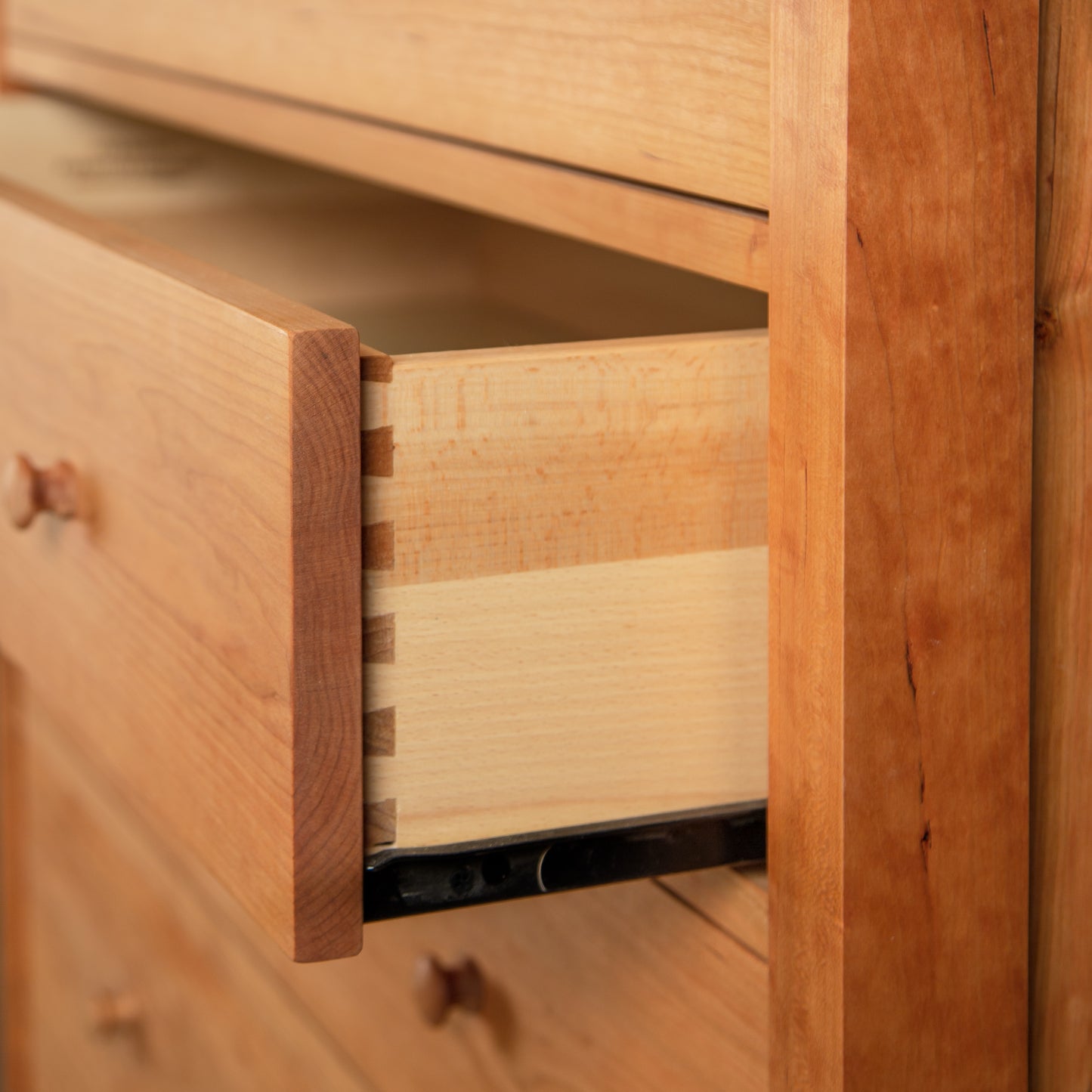 An open Burlington Shaker 6-Drawer Chest demonstrating its dovetail joinery and sliding mechanism by Vermont Furniture Designs.