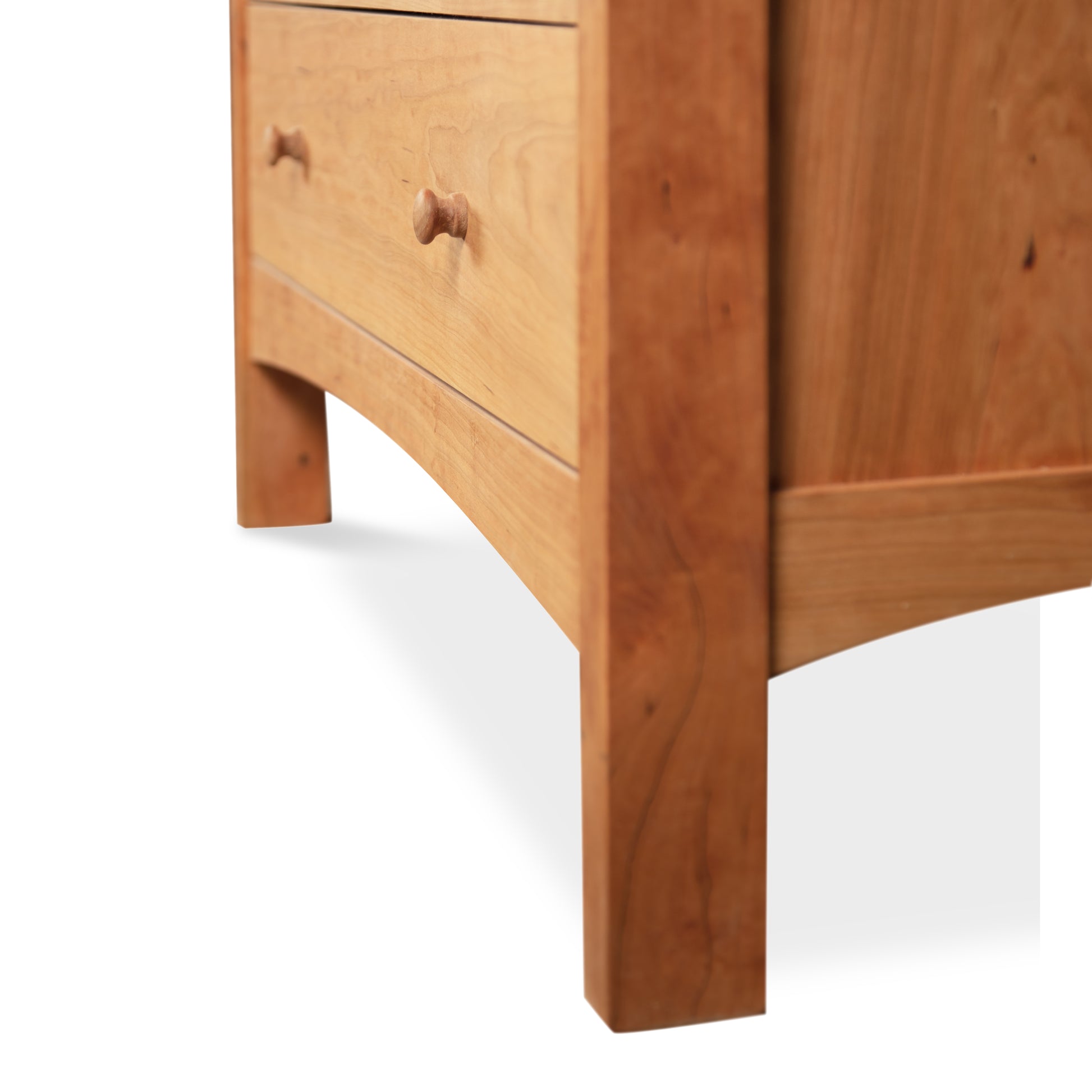 Solid wood Vermont Furniture Designs Burlington Shaker 6-Drawer Chest with two visible drawers, featuring simple knobs and standing on a solid base with curved legs, isolated on a white background.