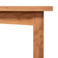 A close-up of a Burlington Shaker Bench from Vermont Furniture Designs, showing the top and leg with a white background.