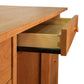 A handmade, solid wood Burlington Shaker Executive Desk with an open drawer displaying its construction and metal drawer slide mechanism by Vermont Furniture Designs.