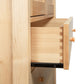 Burlington Shaker Tall Armoire by Vermont Furniture Designs, showcasing an open dovetailed drawer and elegant knobs, crafted from light wood.
