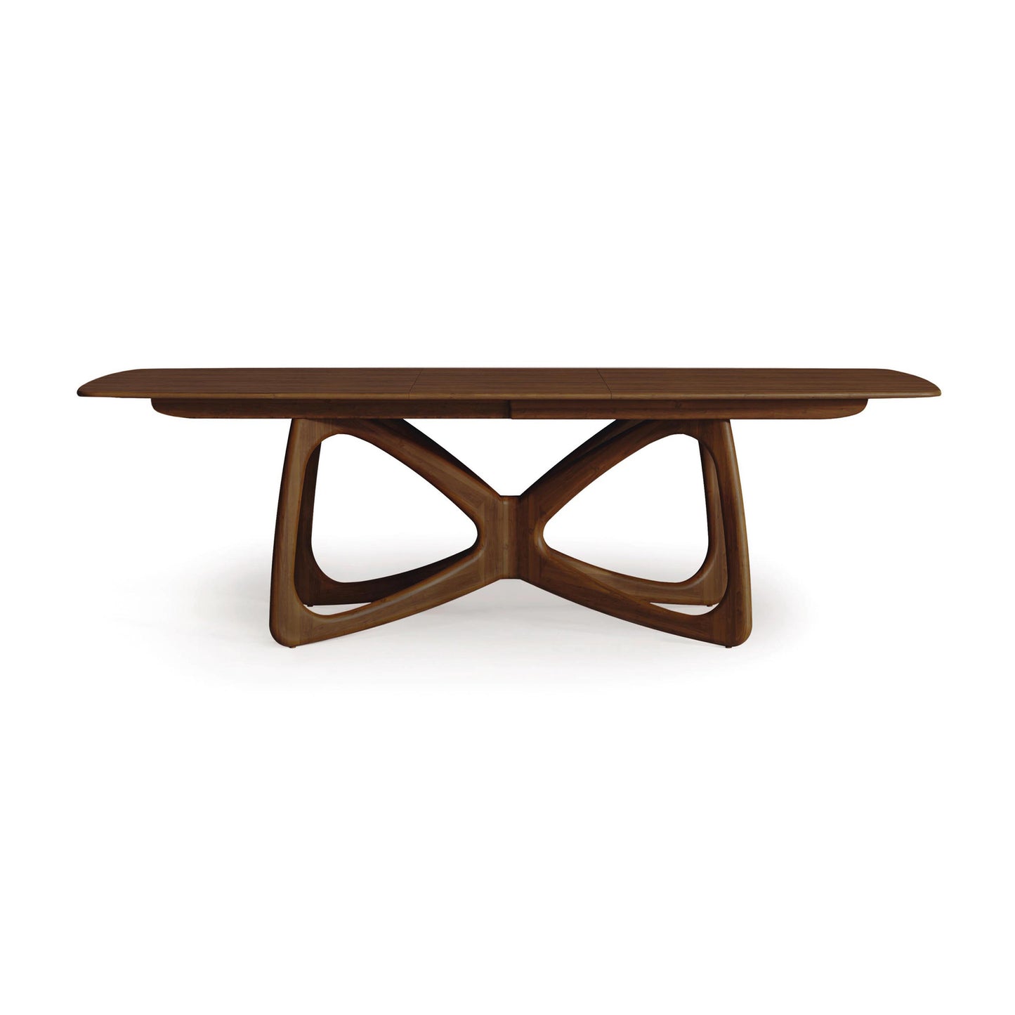 Alt text: Solid wood dining table from Copeland Furniture with modern design featuring a Butterfly Extension. The table has a rectangular top and unique intersecting curved supports forming an X-shaped base, made from sustainably sourced dark brown hardwoods. This American-made furniture piece represents high-quality craftsmanship in walnut wood.