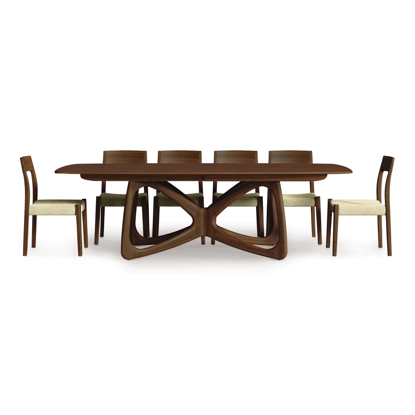 Alt text: Solid wood modern dining table set by Copeland Furniture featuring an oval Butterfly Extension Dining Table with double pedestal base, interlocking supports, and six matching wooden chairs with beige cushions. Sustainably sourced hardwood construction. Open backrest chairs on a white background.