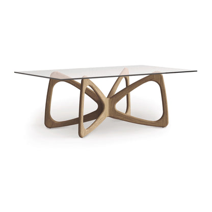 A contemporary dining table from Copeland Furniture, the Butterfly Glass Top Dining Table features a clear glass surface and a sculpturally intertwined wooden base crafted from sustainably sourced hardwoods, enhancing modern aesthetics.