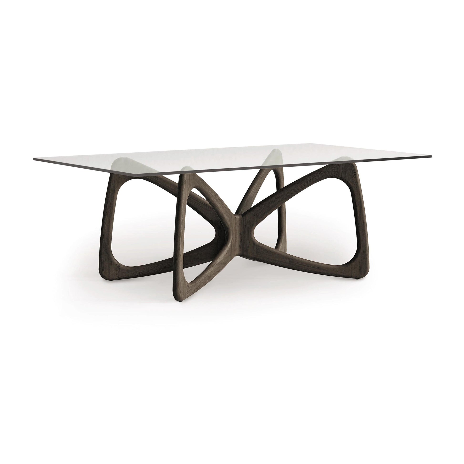 Introducing the Butterfly Glass Top Dining Table by Copeland Furniture: a rectangular glass dining table showcasing a distinctive, sculptural wooden base made from sustainably sourced hardwoods. Its geometric, interconnected loops artfully combine modern design with the elegance of nature.