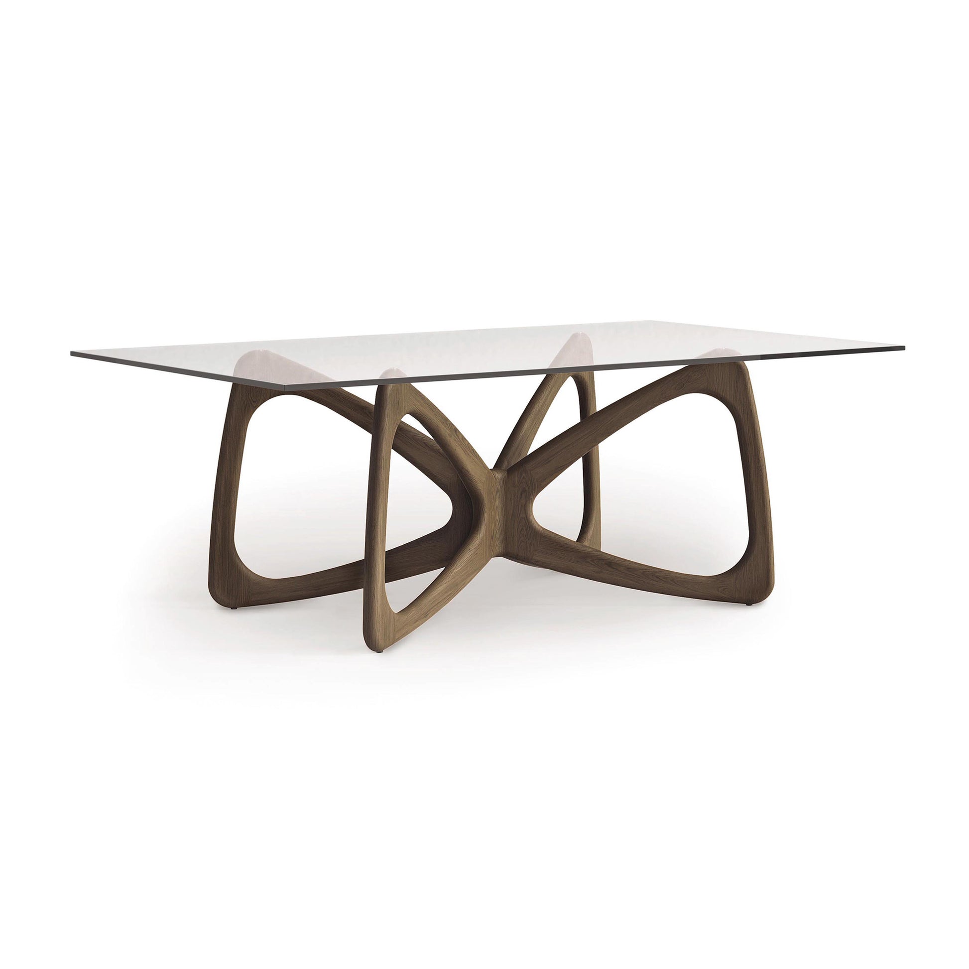 The Butterfly Glass Top Dining Table by Copeland Furniture showcases a modern wooden base made from sustainably sourced North American hardwoods, featuring intersecting curved lines for an open, airy appearance.