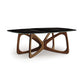 American-made glass coffee table featuring a sculptural interlocking wood base, inspired by Copeland Furniture's Butterfly style.