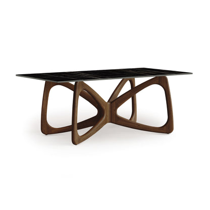 Butterfly Sintered Stone Top Table by Copeland Furniture showcasing its eco-friendly stone top and elegantly curved wooden base with geometric shapes.