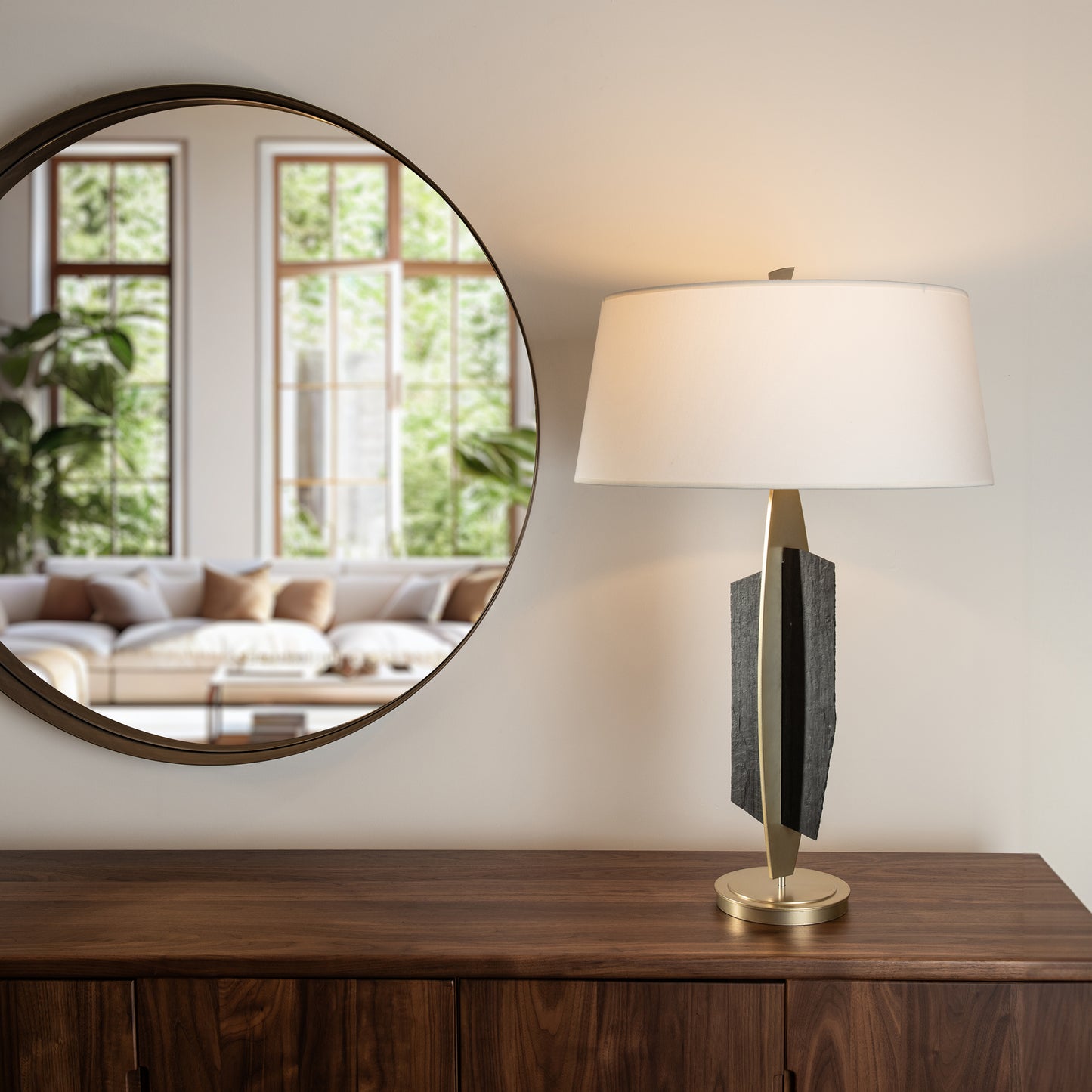 Hubbardton Forge Cambrian Table Lamp with white shade on a wooden sideboard, showcasing modern elegance.