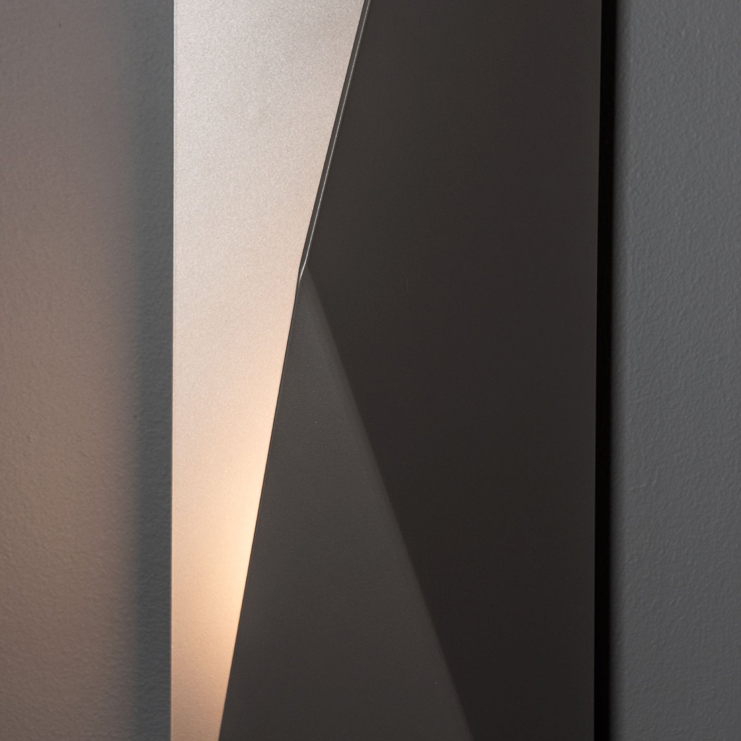 Hubbardton Forge Carbon Large Outdoor Sconce featuring angled panels and a modern design, showcased against a subtle gray background.