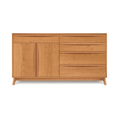 Introducing the Catalina 5-Drawer, 2-Door Dresser by Copeland Furniture—a beautifully crafted wooden sideboard in a light brown finish. This solid wood piece features five drawers on the right side and a tall cabinet with two doors on the left. Standing on short, angled legs, its minimalist design makes it an ideal addition to your bedroom storage needs.