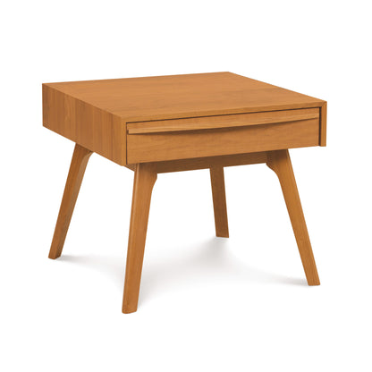 A Catalina 1-Drawer Nightstand by Copeland Furniture, made of solid wood with a single drawer, standing on four slanted legs, isolated on a white background.