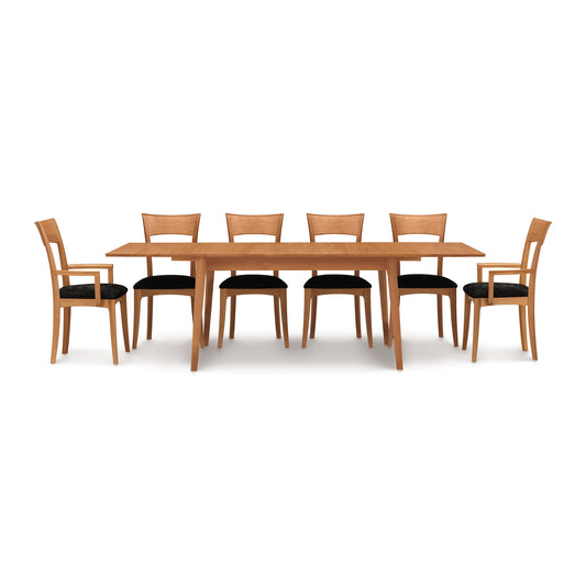 Copeland Catalina Extension Table with six matching wooden chairs featuring black cushioned seats, all crafted in high-quality wood.