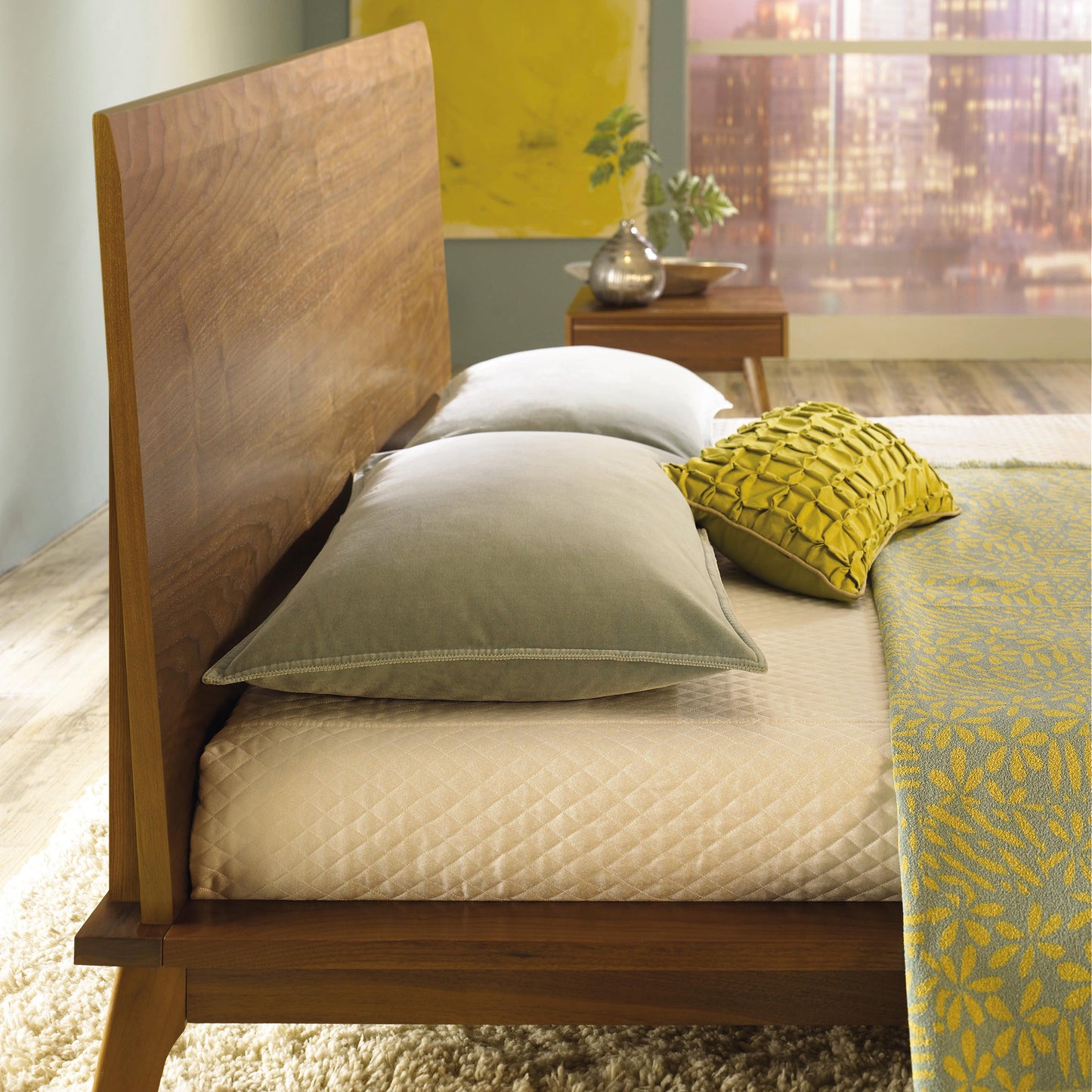 Catalina Platform Bed by Copeland Furniture with gray and yellow pillows, textured bedspread, and nightstand.