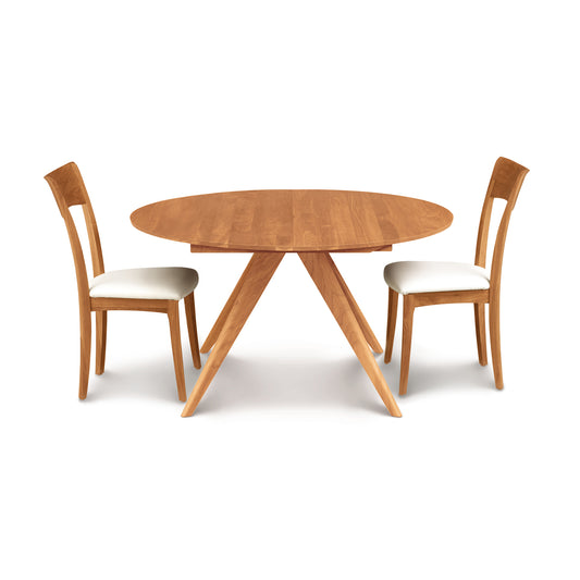 The Catalina Round Extension Table from Copeland Furniture is a fine dining furniture piece made from solid North American wood. It comes with two chairs, making it the perfect addition to any dining space.