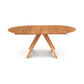 A wooden oval dining table with three legs.