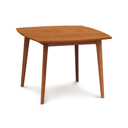 A Copeland Furniture Catalina Solid-Top Table with four legs and a trapezoidal tabletop, isolated on a white background.