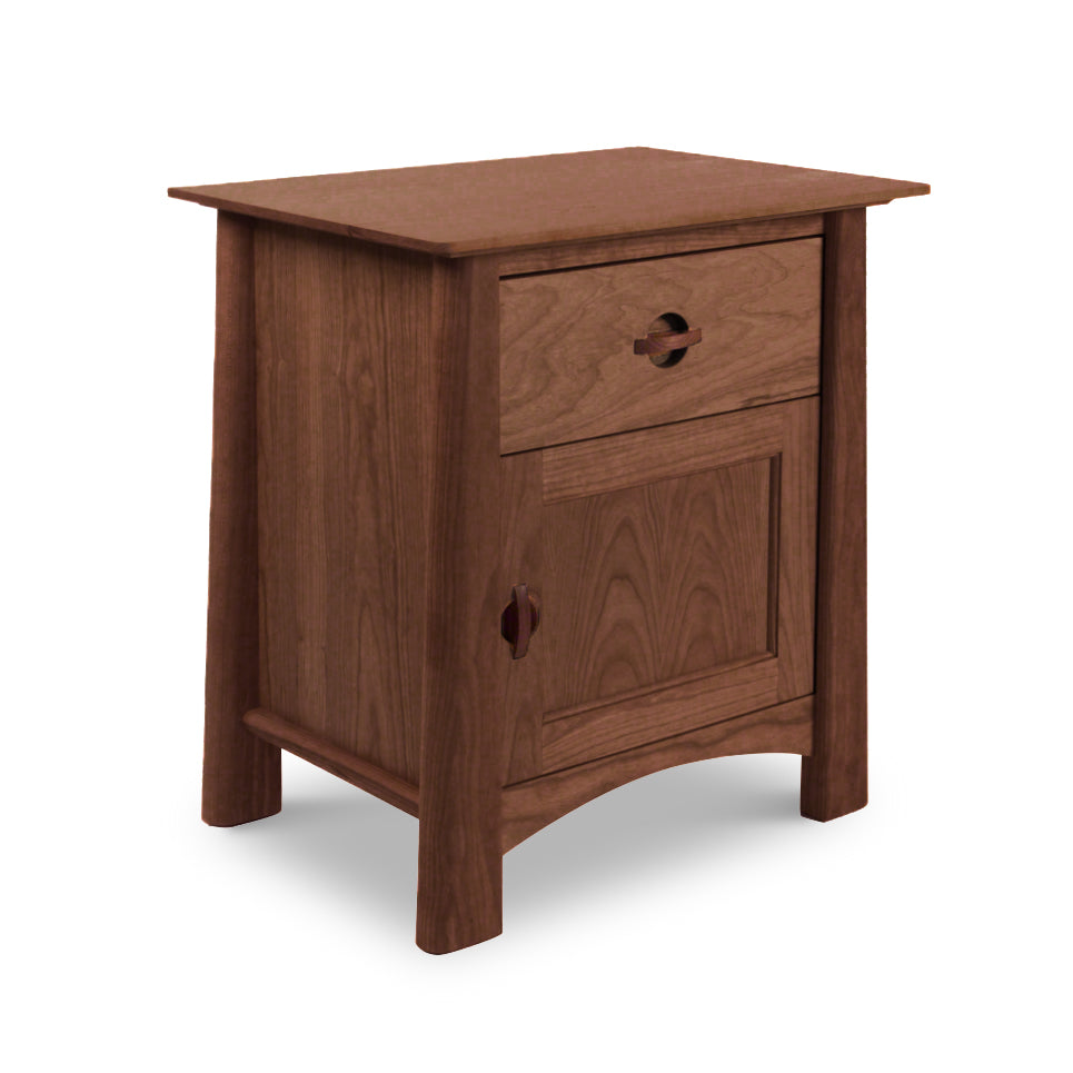 A Cherry Moon 1-Drawer Nightstand With Door from Maple Corner Woodworks, with a smooth finish, featuring a single drawer and a cabinet door, both with round knobs. The table stands on four angled legs and is isolated against a white background.