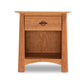 The Cherry Moon wooden bedside table by Maple Corner Woodworks, featuring a single drawer with a circular handle and an open shelf below it, is part of the sustainable Cherry Moon 3-Piece Bedroom Set - Ready to Ship. With its light brown finish, the table boasts a simple yet functional design.