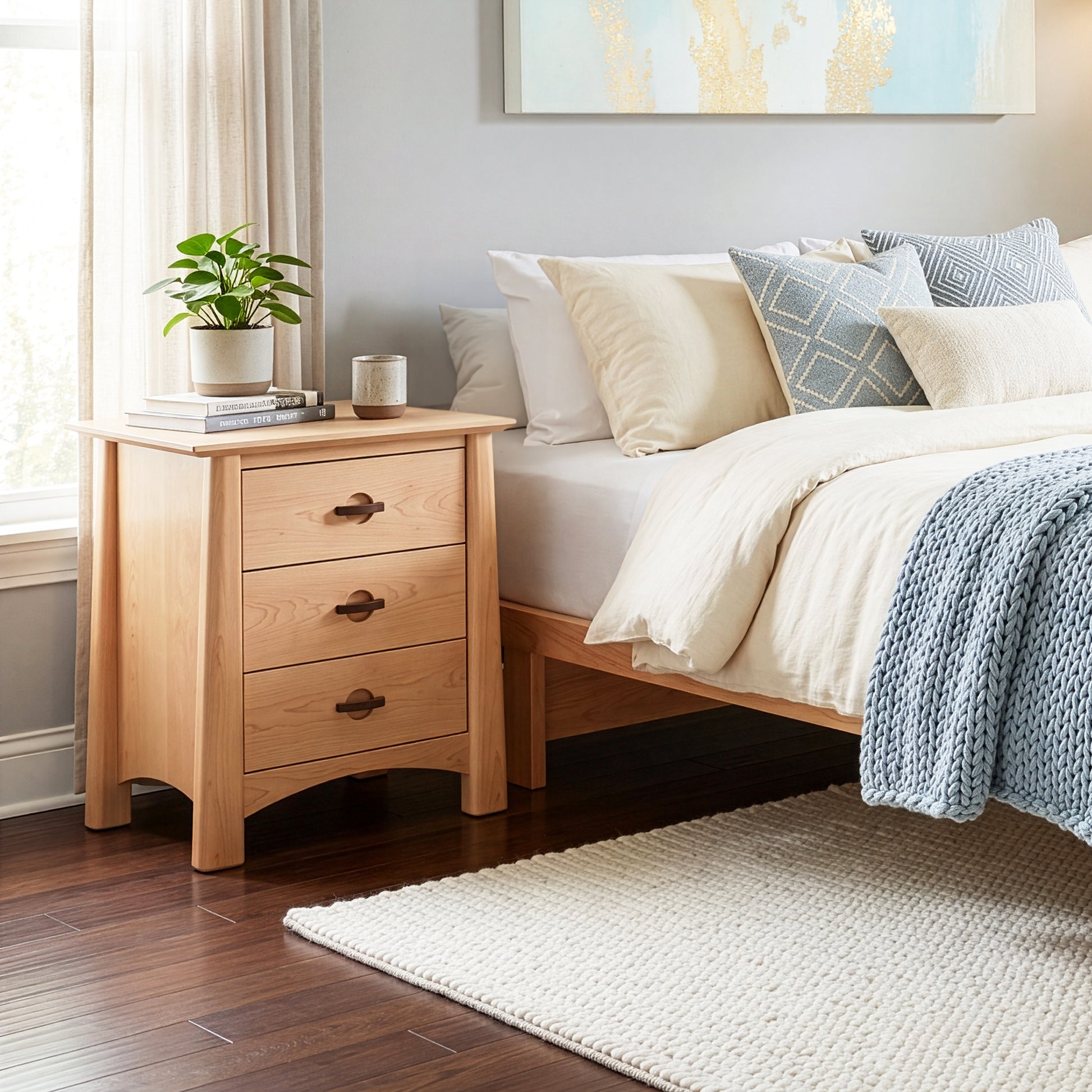 Cherry Moon 3-Drawer Nightstand by Maple Corner Woodworks, handcrafted in solid wood, shown beside a bed.