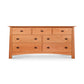 An eco-friendly Cherry Moon 7-Drawer Dresser handmade in Vermont by Maple Corner Woodworks from sustainably harvested solid woods, featuring drawers, set against a pristine white background.