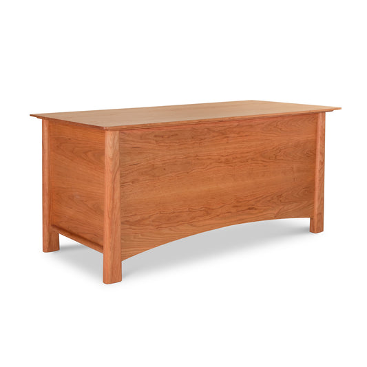 A Cherry Moon Blanket Chest with a hinged lid, crafted from cherry wood with a smooth finish. It features simple, sturdy legs and a modest design, isolated on a white background. This piece exemplifies Maple Corner Woodworks's craftsmanship.