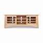 Cherry Moon 68″ TV console by Maple Corner Woodworks in light cherry wood with two glass cabinets, three open shelves, and built-in cord management.
