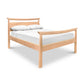 A Maple Corner Woodworks Cherry Moon Pagoda Bed frame crafted from natural cherry hardwood, featuring a clean, modern design with a curved headboard influenced by Eastern aesthetics. It is outfitted with a white mattress and two pillows.