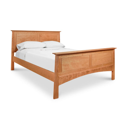Cherry Moon Panel Bed by Maple Corner Woodworks with cherry wood headboard and footboard, dressed in white sheets and pillows.