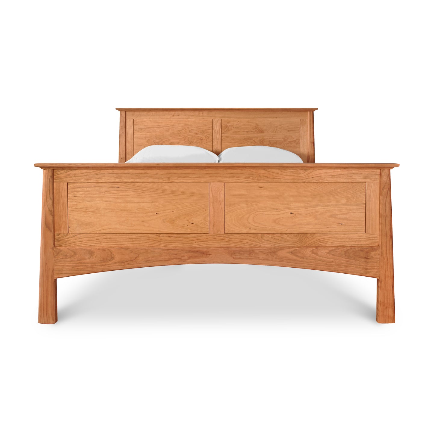A Maple Corner Woodworks Cherry Moon Panel Bed with a curved headboard and two white pillows, isolated against a white background. The bed features distinct wood grain patterns and a footboard.