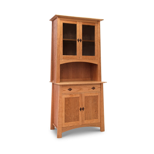 Natural Cherry Moon Small China Cabinet by Maple Corner Woodworks, showcasing luxury American made kitchen furniture. Features two glass-paneled doors on top, open shelf in middle, two solid wood doors on bottom. Solid wood furniture with metal handles and slightly flared base design.
