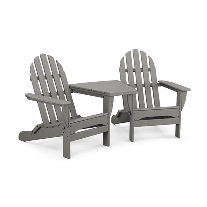 Two gray POLYWOOD Classic Folding Adirondack chairs connected by a small table, displayed on a white background. The furniture setup suggests a relaxed outdoor seating arrangement.