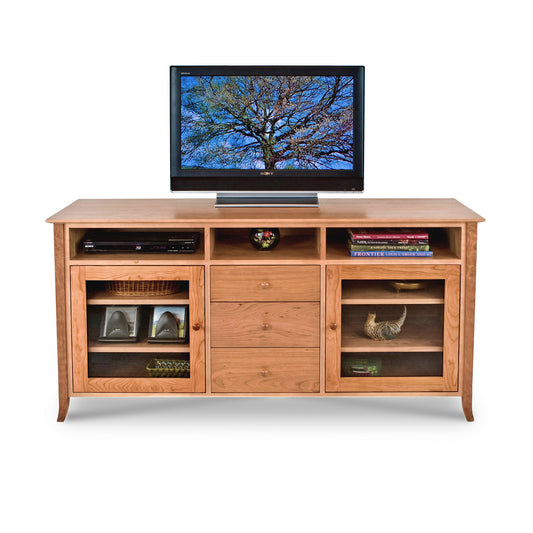 An American-made wooden Lyndon Furniture Classic Shaker 64" Flare Leg Media Center with a vintage shaker style and a tv on top.