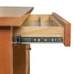 Close-up of the Lyndon Furniture Small Wood Flare Leg Executive Desk with a partially open drawer showcasing the quality wood craftsmanship and metal sliding mechanism.