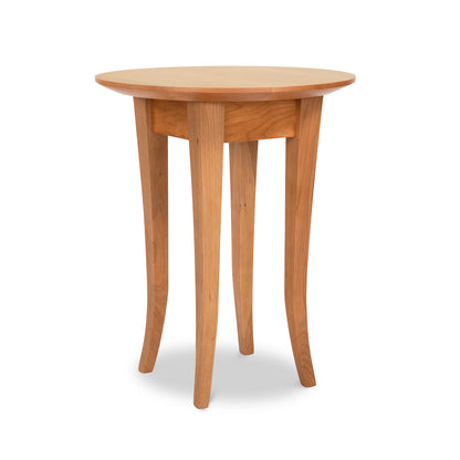 A Classic Shaker Round Flare Leg End Table from the Lyndon Furniture Collection with four slender, slightly curved legs, against a plain white background. The table is light brown and appears smooth with a simple, classic design.