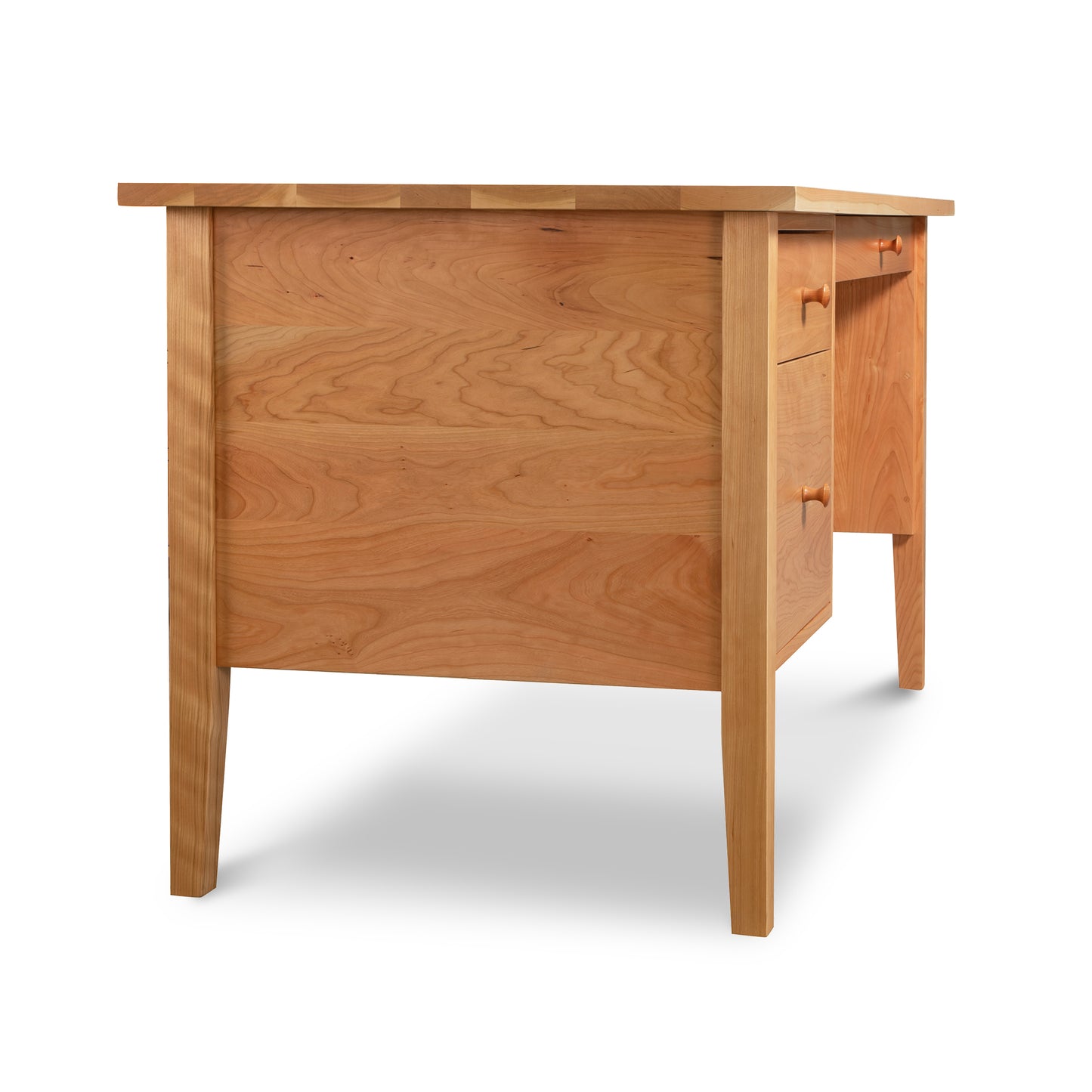 Shaker-Style Solid Wood Executive Desk with Natural Finish by Lyndon Furniture - Three-Quarter Rear View. This American-Made Desk Features Four Straight Legs, Smooth Top Surface, and Side Drawer with Two Round Wooden Knobs for Simple Functionality. Ideal for Home Offices Seeking High-Quality Craftsmanship.