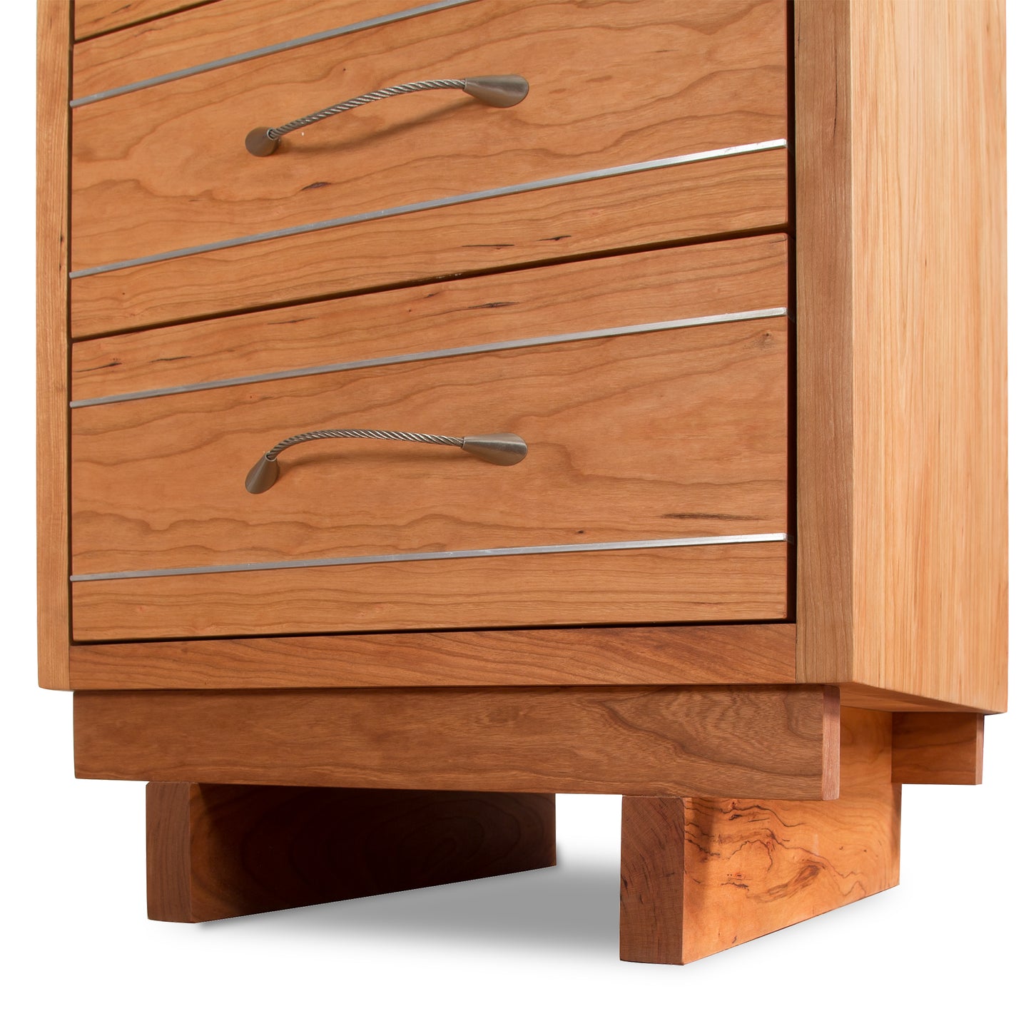 A close-up of a Vermont Furniture Designs Contemporary Cable 3-Drawer Nightstand featuring dovetail drawers, metal handles, and a solid base.
