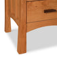 A Vermont Furniture Designs Contemporary Craftsman 3-Drawer nightstand, providing storage space.