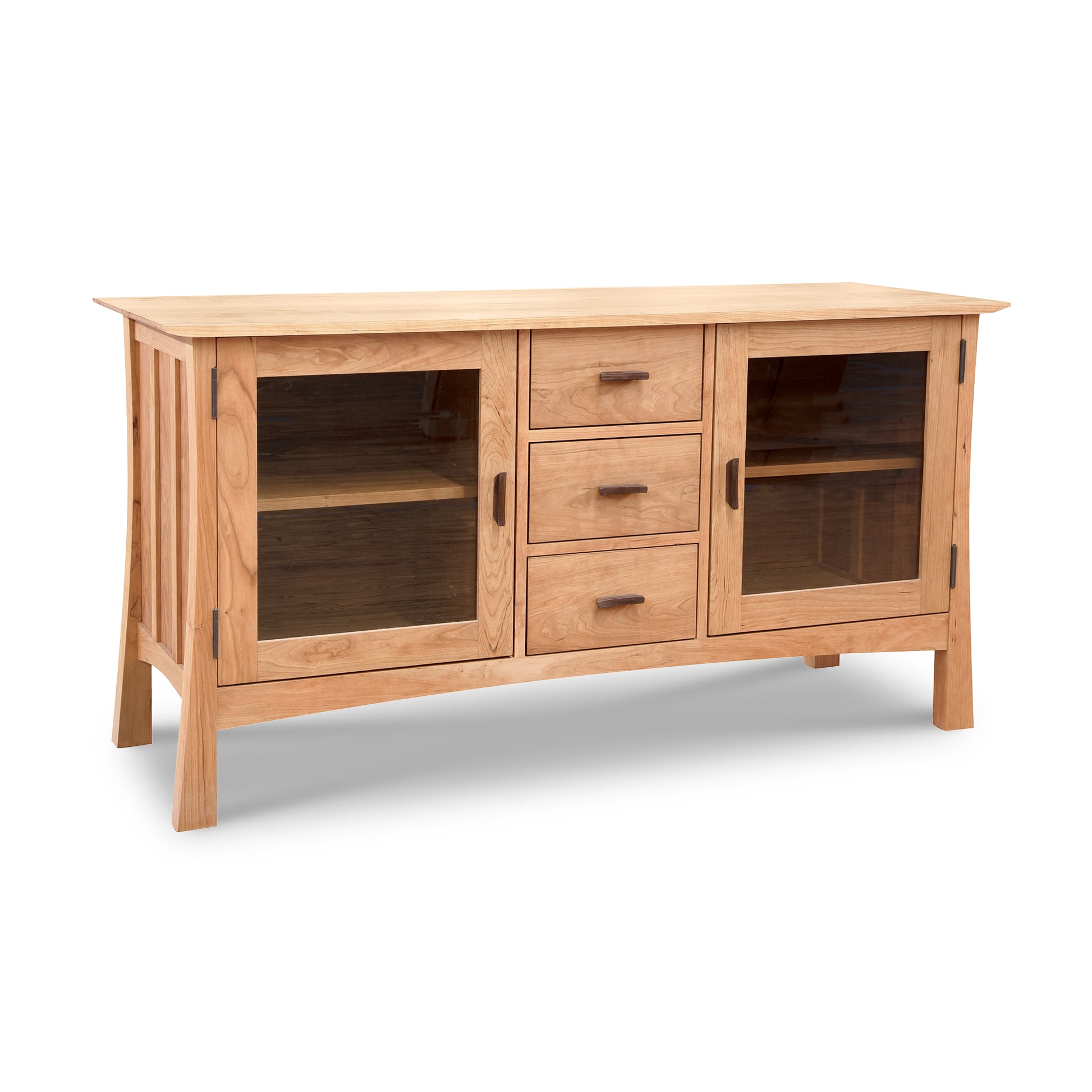 Vermont Furniture Designs Contemporary Craftsman 3-Drawer Media Console with glass-paneled doors, made from solid wood in a natural cherry finish on a white background.