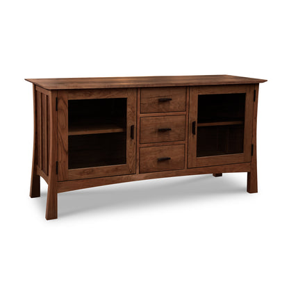 Introducing the Contemporary Craftsman 3-Drawer Media Console by Vermont Furniture Designs. This solid wood media console features a natural finish, two mesh-front cabinets with black handles, and three central drawers. The piece stands on four straight legs and is perfect for any stylish media setup. Ideal for those seeking American made furniture, cherry wood furniture, walnut wood furniture, or maple furniture in a mid-century modern design.

