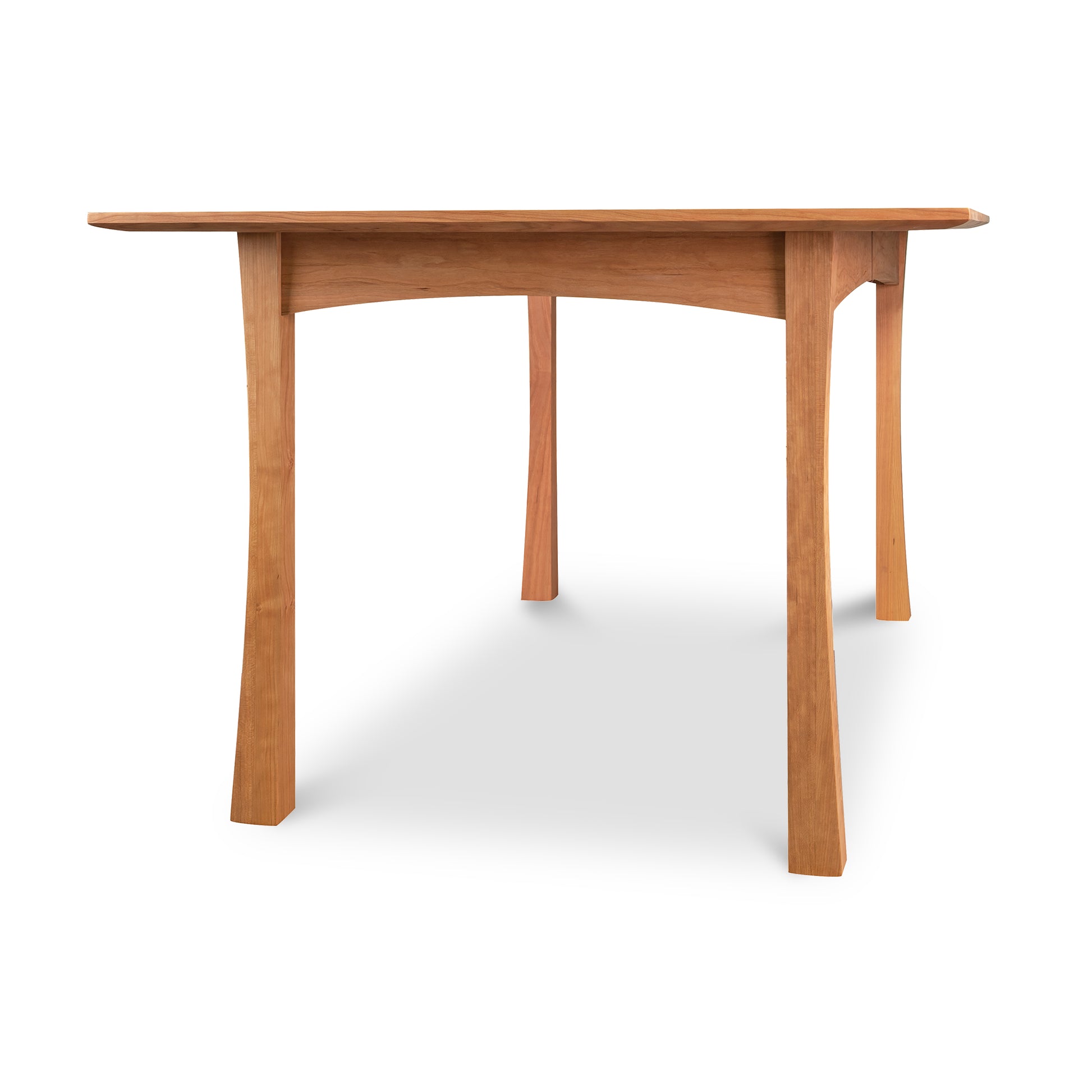 A Contemporary Craftsman Extension Dining Table, crafted by Vermont Furniture Designs woodworkers, with a simple design and four legs, isolated on a white background.