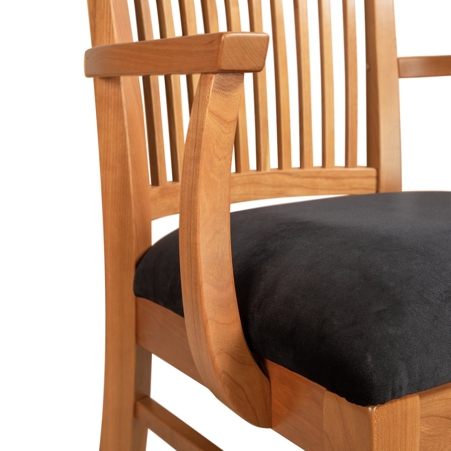 A wooden chair with a black cushion.