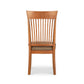 A wooden dining chair with a tan seat.